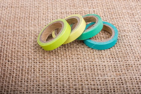 Colorful insulating adhesive tape on linen canvas background