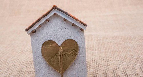 Heart shape icon placed on a little model house