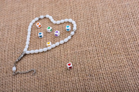 Heart shaped cubes in hand by inside a praying beads