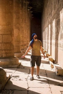 Young man in blue turban walking on the columns of the Edfu Temple near the city of Aswan. Egypt