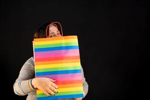 Woman holding lgbt bag. Joy of consumption. Purchases