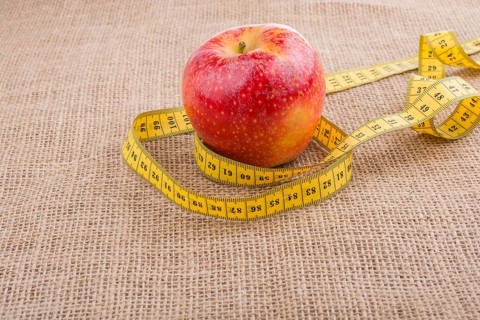 Health and diet concept with apple with a measurement tape