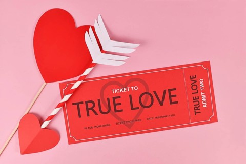 Cute Valentine's day concept with 'True Love' ticket and cupid arrow on pink background