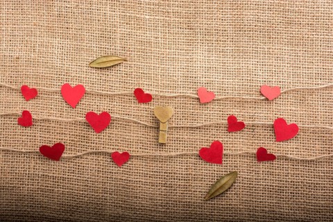 Love concept with heart shaped papers on linen threads