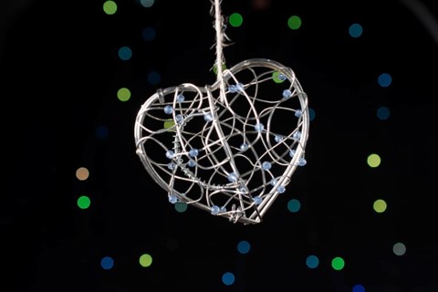 Heart shaped metal cage on a bokeh light background