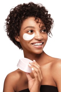 African American skincare models with perfect skin and curly hair with patches under her eyes