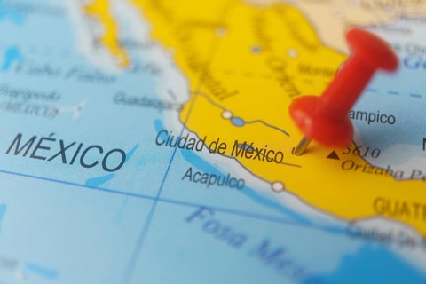 Mexico marked with a red thumbtack on a map with an out-of-focus background