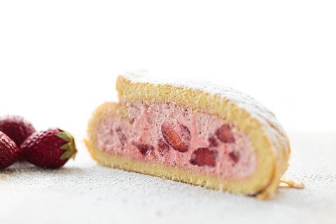 Delicious fruity sponge roll with strawberry filling Strawberry Quark Sponge Roll sprinkled with icing sugar