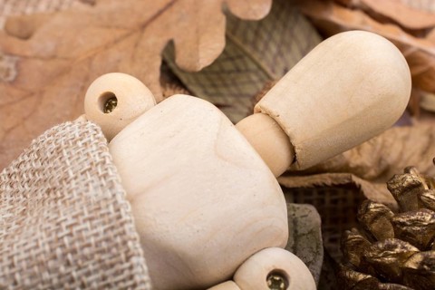 Wooden dolls posing amid autumn background