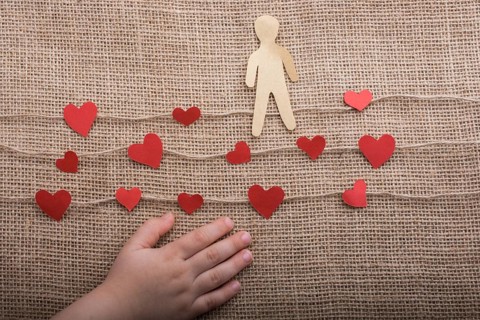 Paper man and heart icons on linen threads on canvas