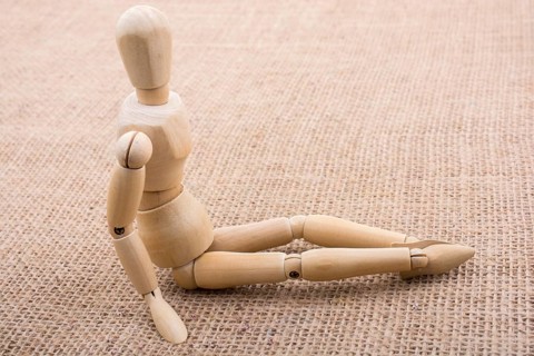 Wooden dolls of a man posing on canvas