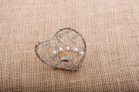 Golden color crown model with pearls on brown background