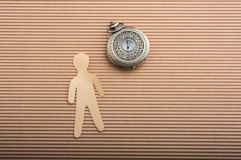 Paper man shape and a retro pocket watch