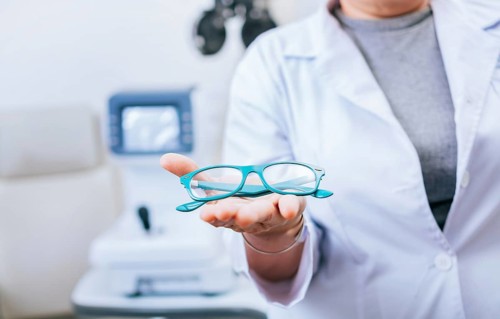 Optometrist hands showing a glasses. Oculist giving glasses in palm hand. Eyeglasses and visual health concept