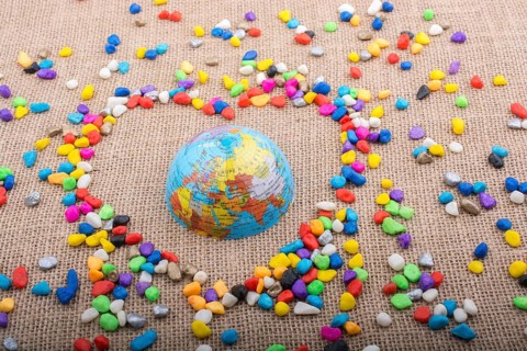 Globe in the heart form shaped by colorful pebbles