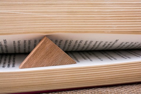 Triangle shaped wood keeping the book open