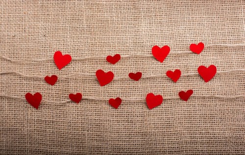 Love concept with heart shaped papers on linen threads