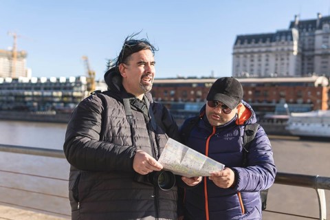 Couple of friends consulting the map while exploring Puerto Madero