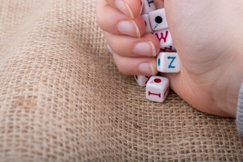 Colorful alphabet letter cubes in handon a canvas background