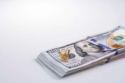 American 100 dollar banknotes and a gold color crown
