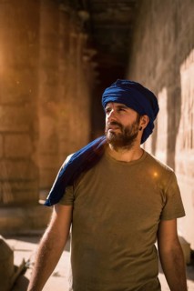 Young man in blue turban walking on the columns of the Edfu Temple near the city of Aswan. Egypt