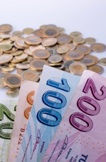Turkish Lira coins and banknotes side by side on white background