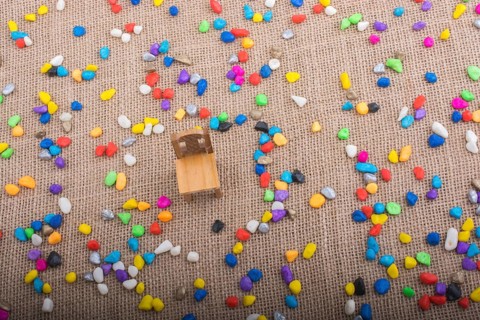 Little chair amid pebbles on canvas background