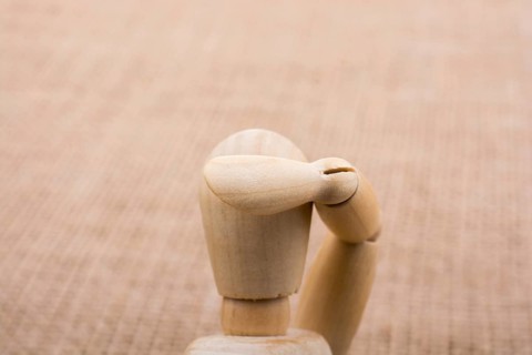 Wooden dolls of a man posing on canvas