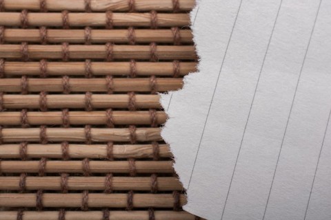 Piece of torn paper on a straw background