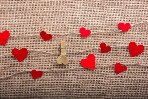Love concept with heart shaped papers on linen threads