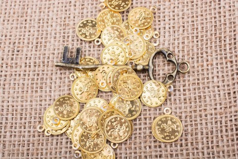 Retro styled key placed over fake gold coins