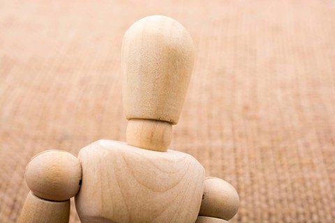 Wooden dolls of a man posing on canvas