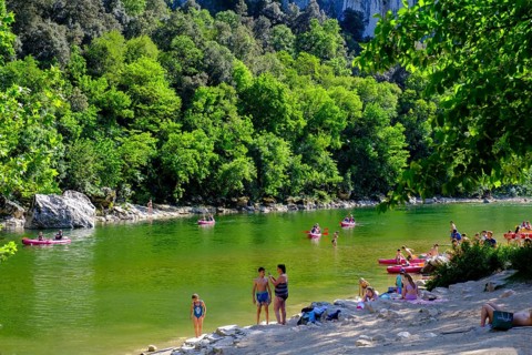 Kayaker and beach at the Pont d'Arc rock arch