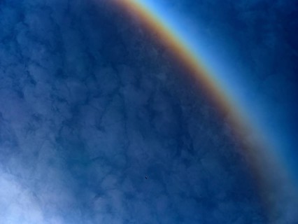 Detail of a sun halo with clouds in the sky and a flying crane