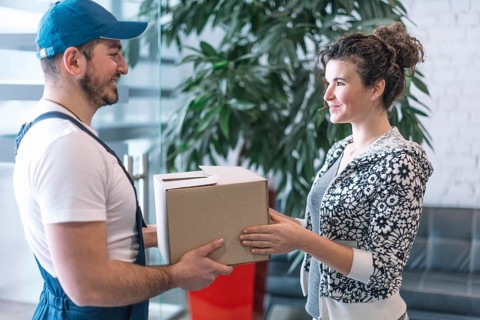 Side view woman taking parcel from deliveryman