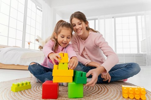 Front view two sisters playing home toys