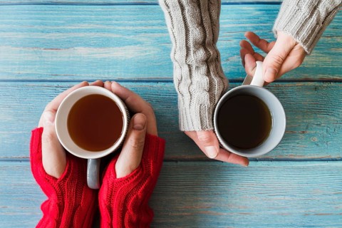 Hands holding cups tea