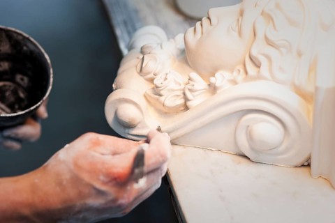 A plasterer restores a stucco figure