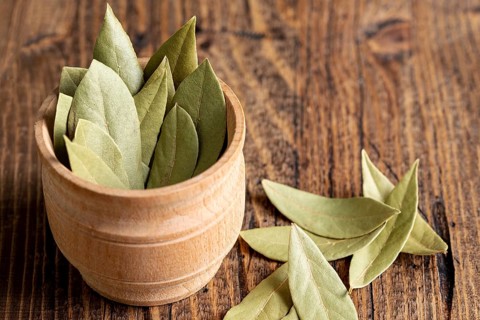 High angle wooden bowl with bay leaves