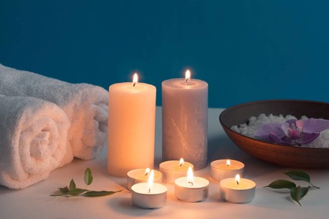 Lighted candles rolled up towel bath spa salt table