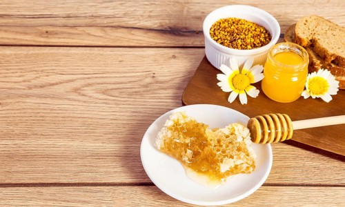 Honeycomb bee pollen honey bread slice wooden surface