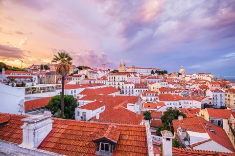 View of Lisbon famous view from Miradouro de Santa Luzia tourist viewpoint over Alfama old city district on sunset with dramatic overcast sky. Lisbon
