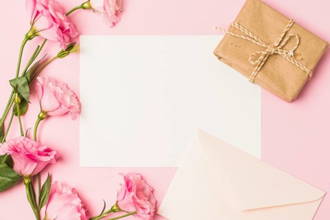 Blank paper with envelop fresh pink flower brown wrapped gift box pink background