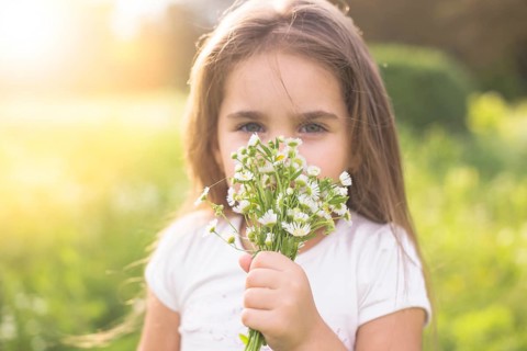 Girl smelling white flowers