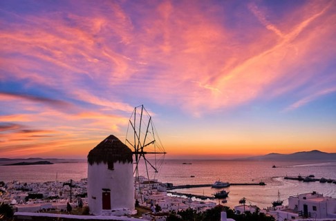 Famous traditional Greek windmill overlook civil port and harbor of Mykonos