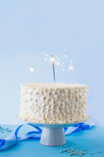 White birthday cake with burning sparkler