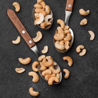Close up spoons filled with healthy raw cashew nuts
