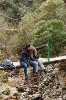 Couple with backpack sitting bridge