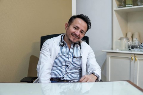 Latin doctor sitting at his desk