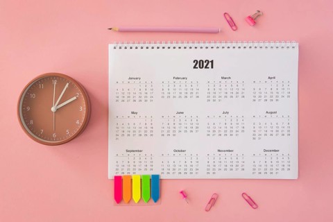 Flat lay desk calendar pink background